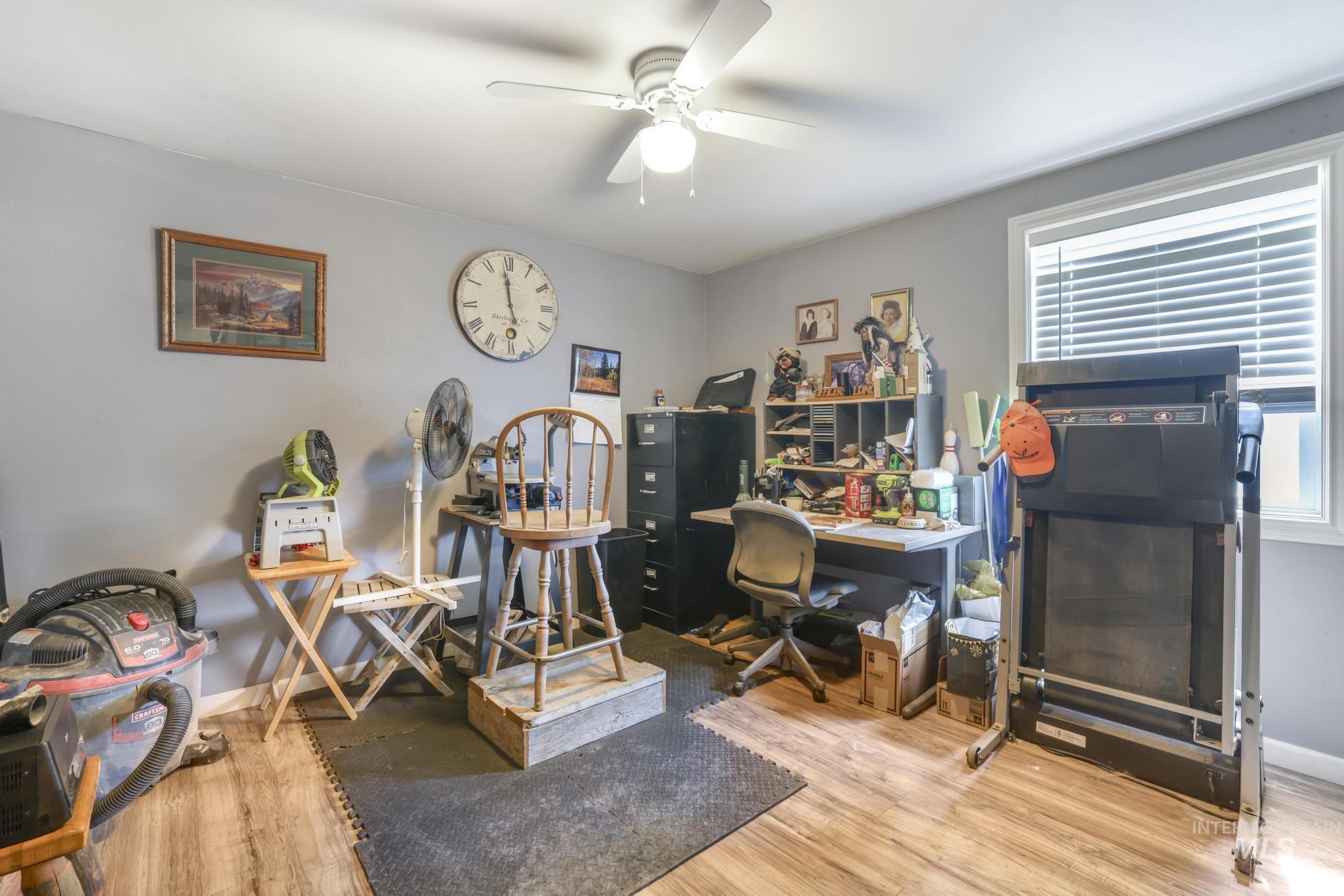 Office space with light wood-style flooring and a ceiling fan