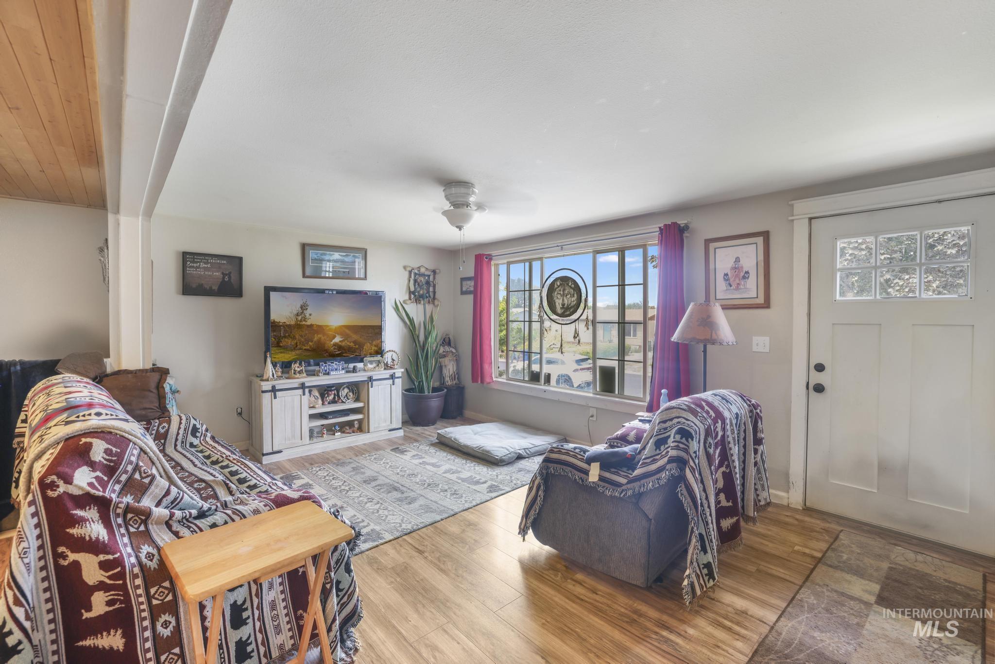 Living area with wood finished floors and a ceiling fan