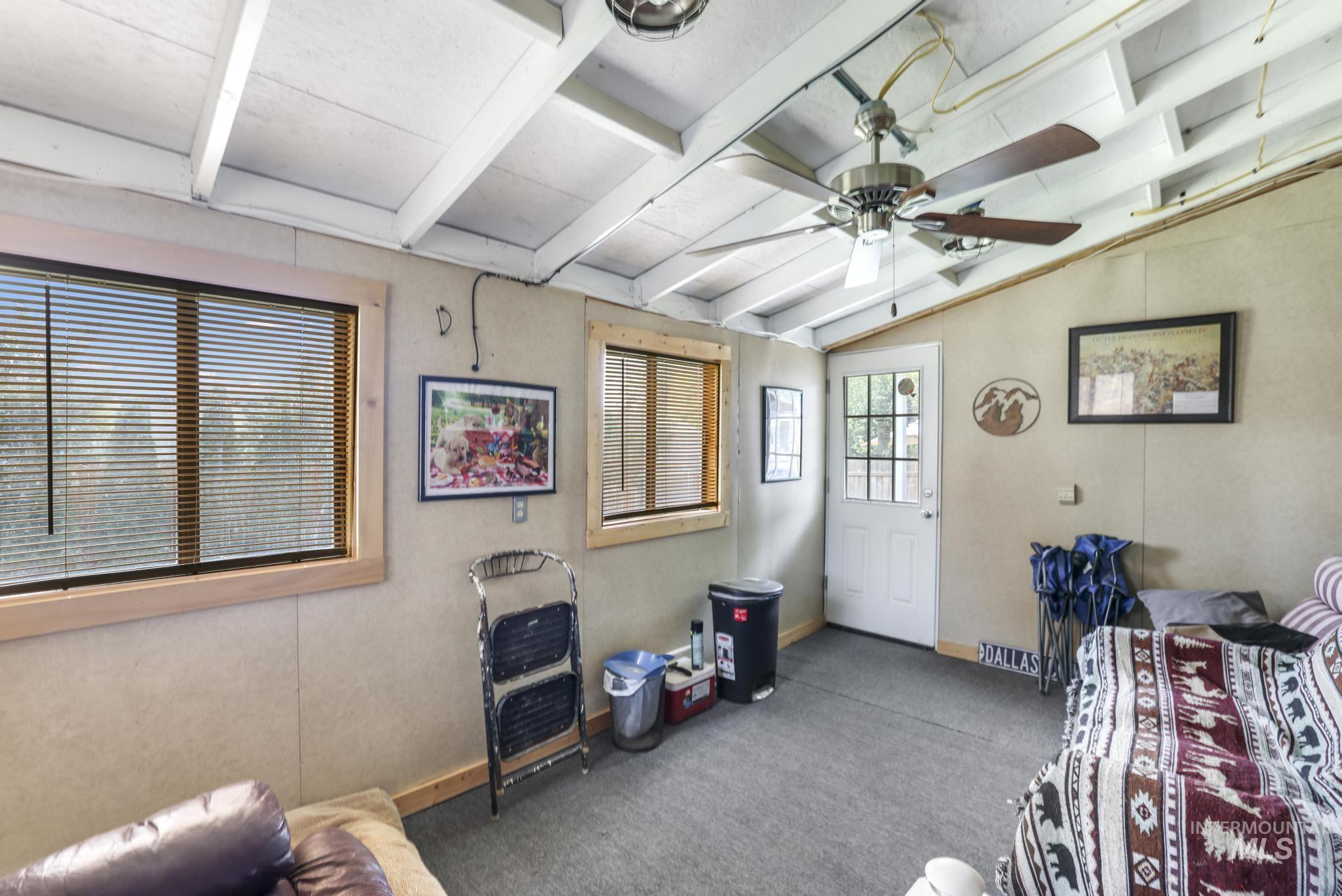 Miscellaneous room with a ceiling fan and carpet flooring