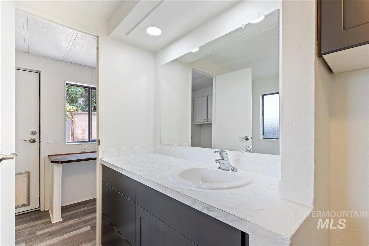 Bathroom with vanity, dark wood-style flooring, and recessed lighting