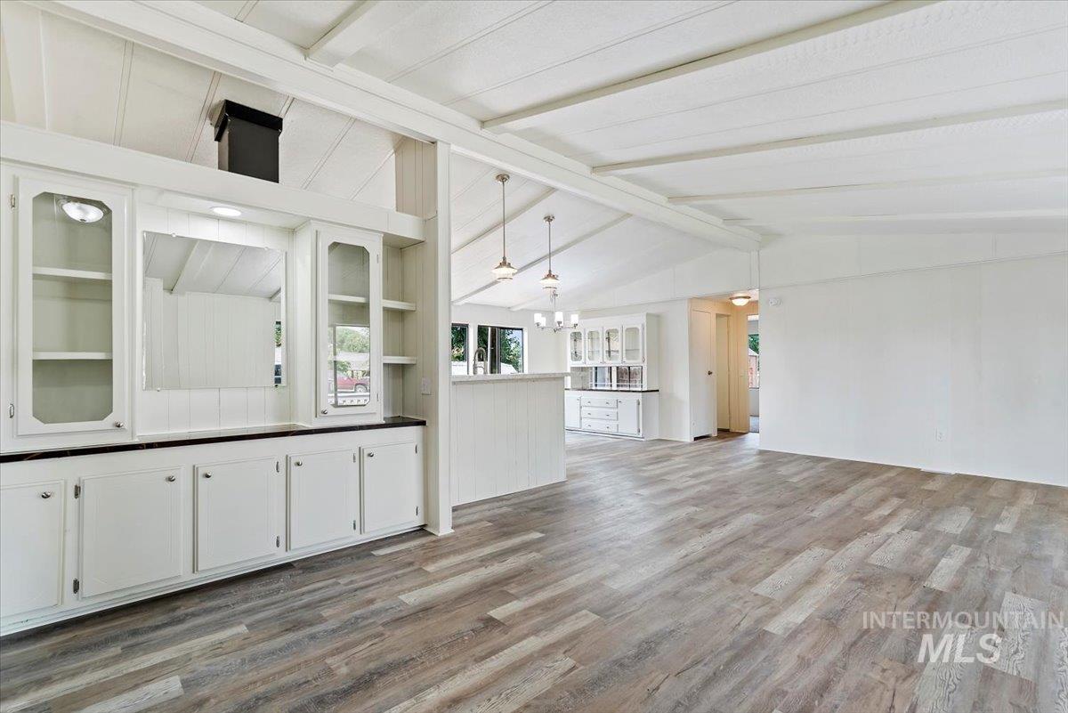 Unfurnished living room with light wood finished floors and a chandelier