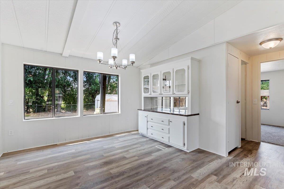 Unfurnished dining area with light wood finished floors and a chandelier