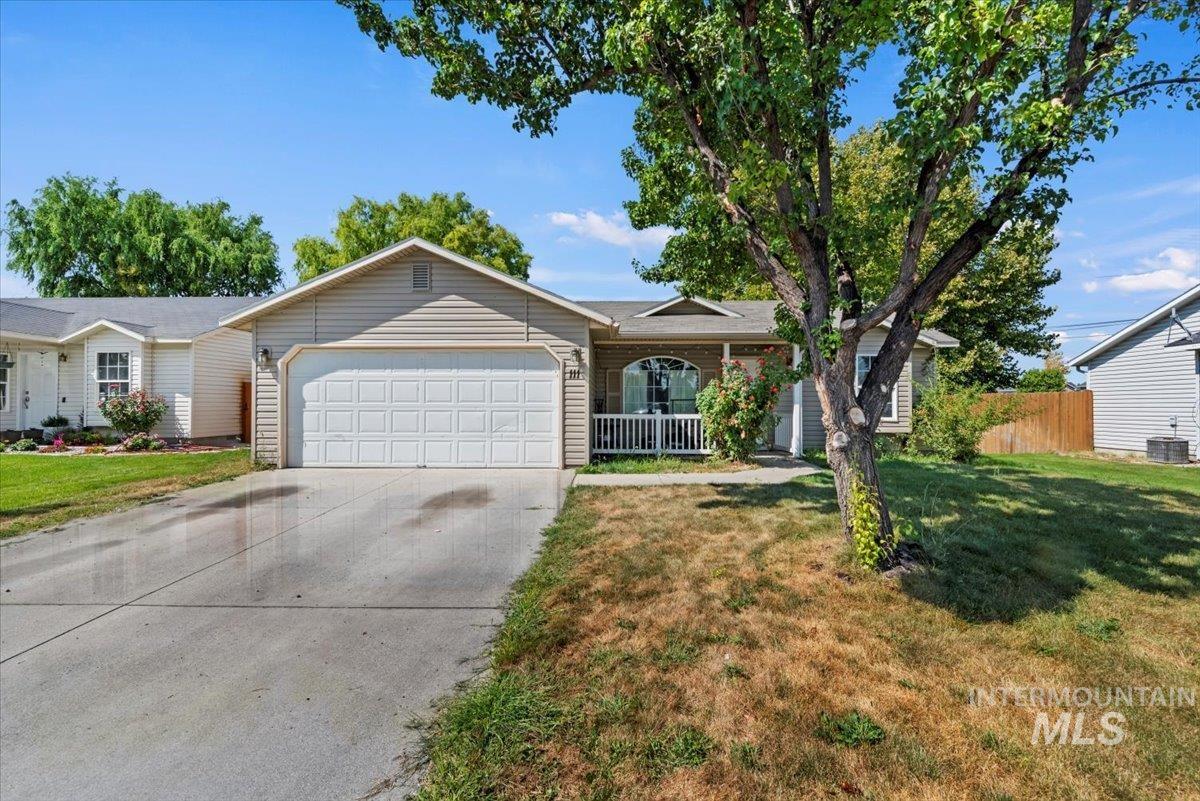 Ranch-style house featuring a porch, driveway, and a garage