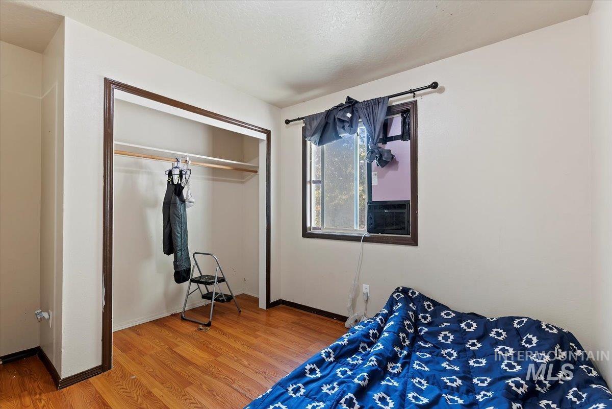Bedroom featuring wood finished floors, a closet, and a textured ceiling
