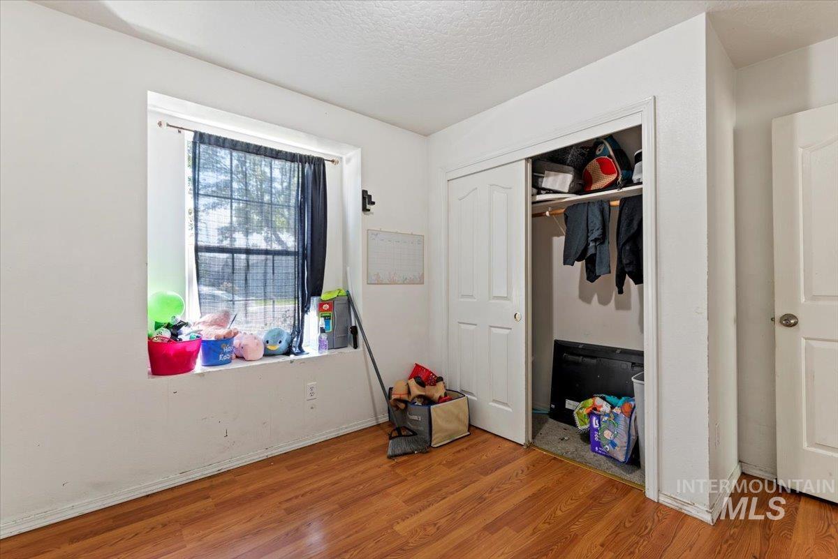 Bedroom featuring wood finished floors, a closet, and a textured ceiling