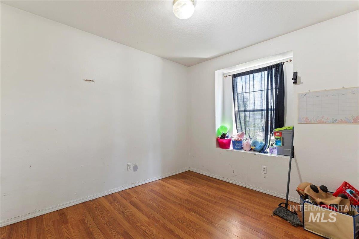 Spare room with wood finished floors and a textured ceiling