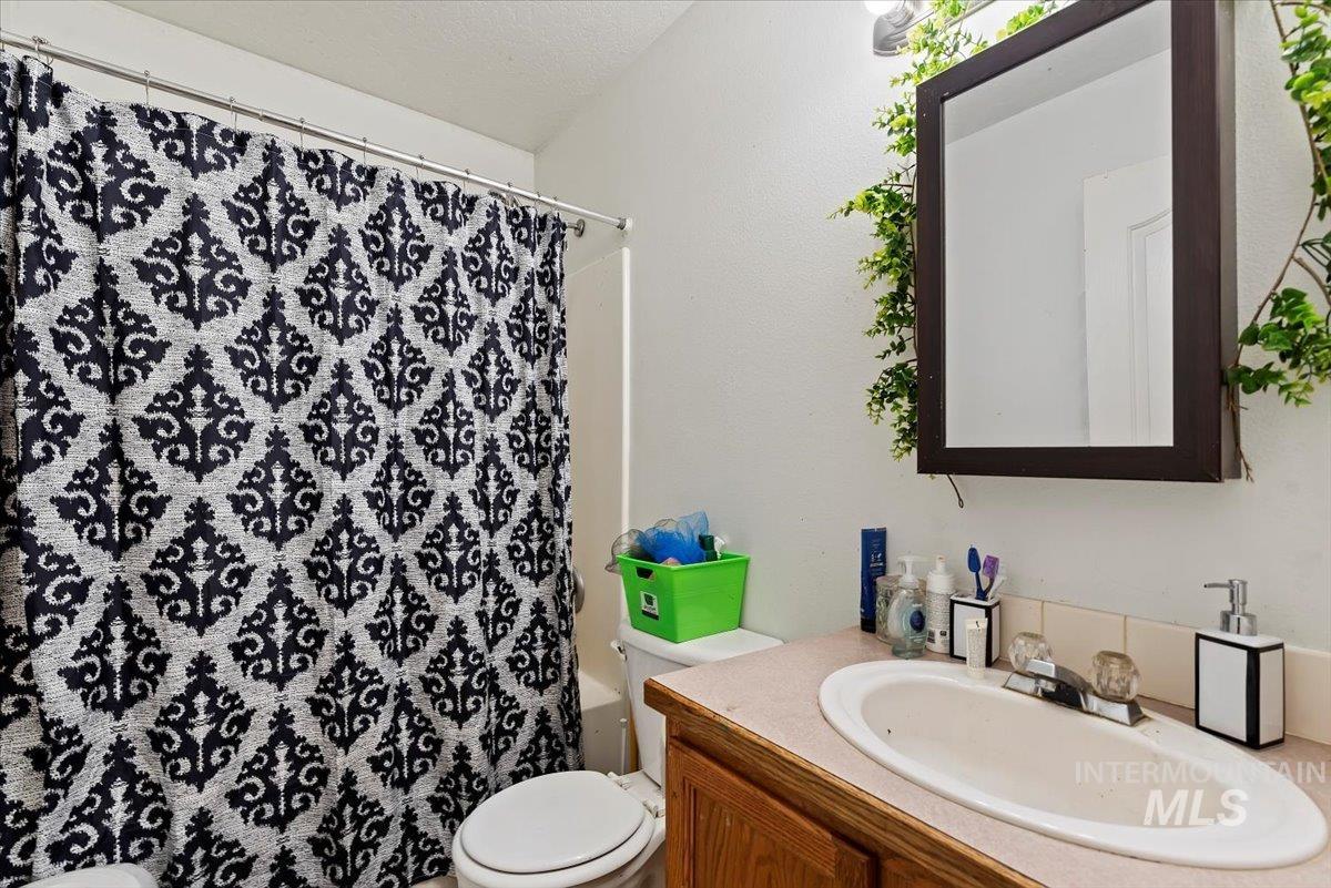 Bathroom featuring vanity and shower / bath combination with curtain