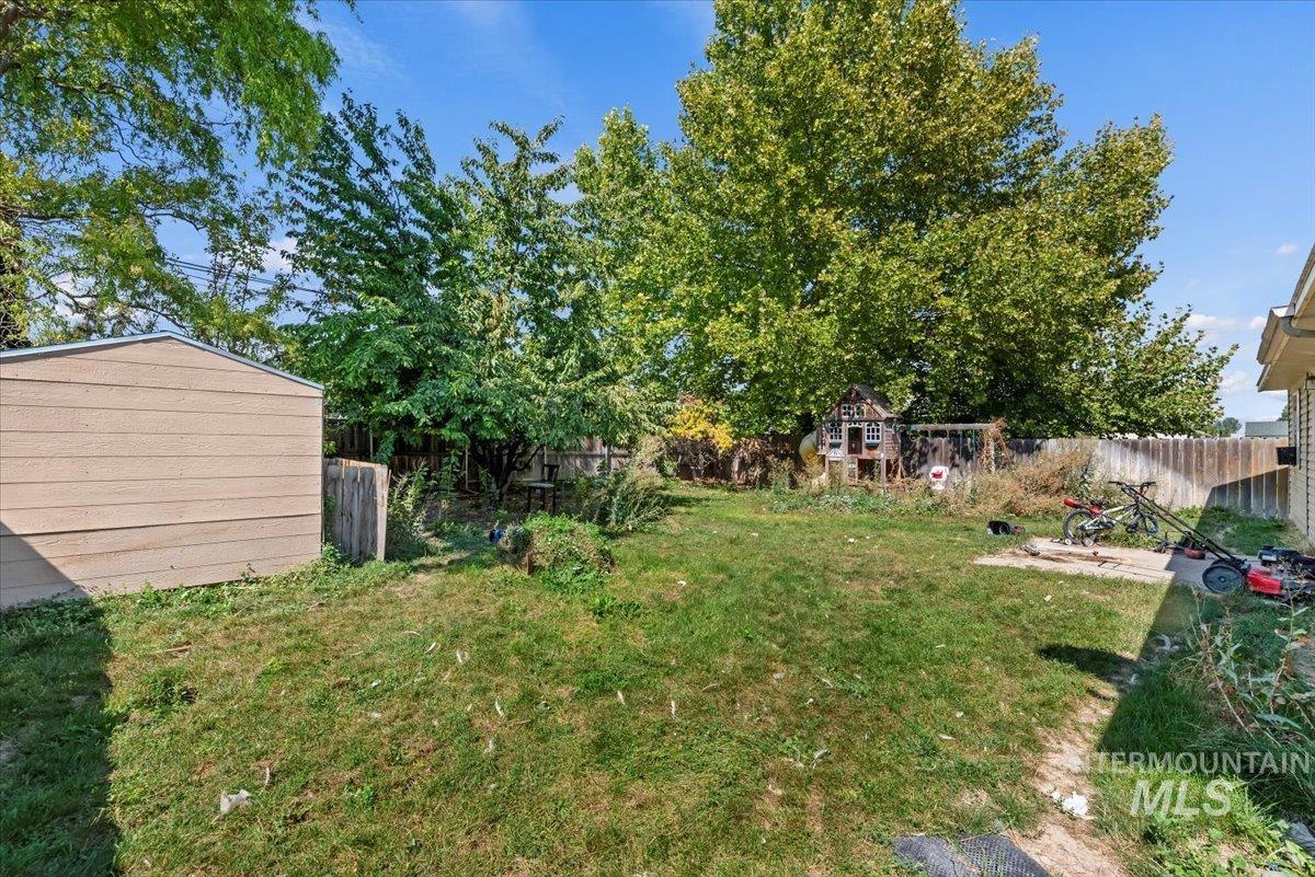 Fenced backyard featuring an outdoor structure