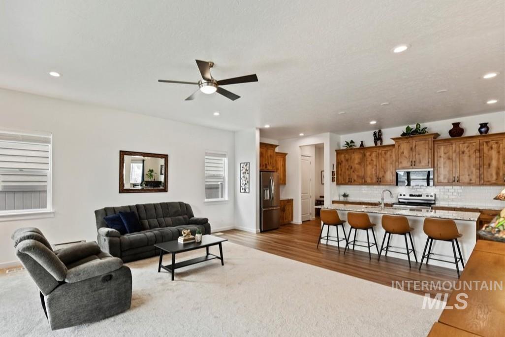 Living area featuring recessed lighting, light wood-style floors, and ceiling fan