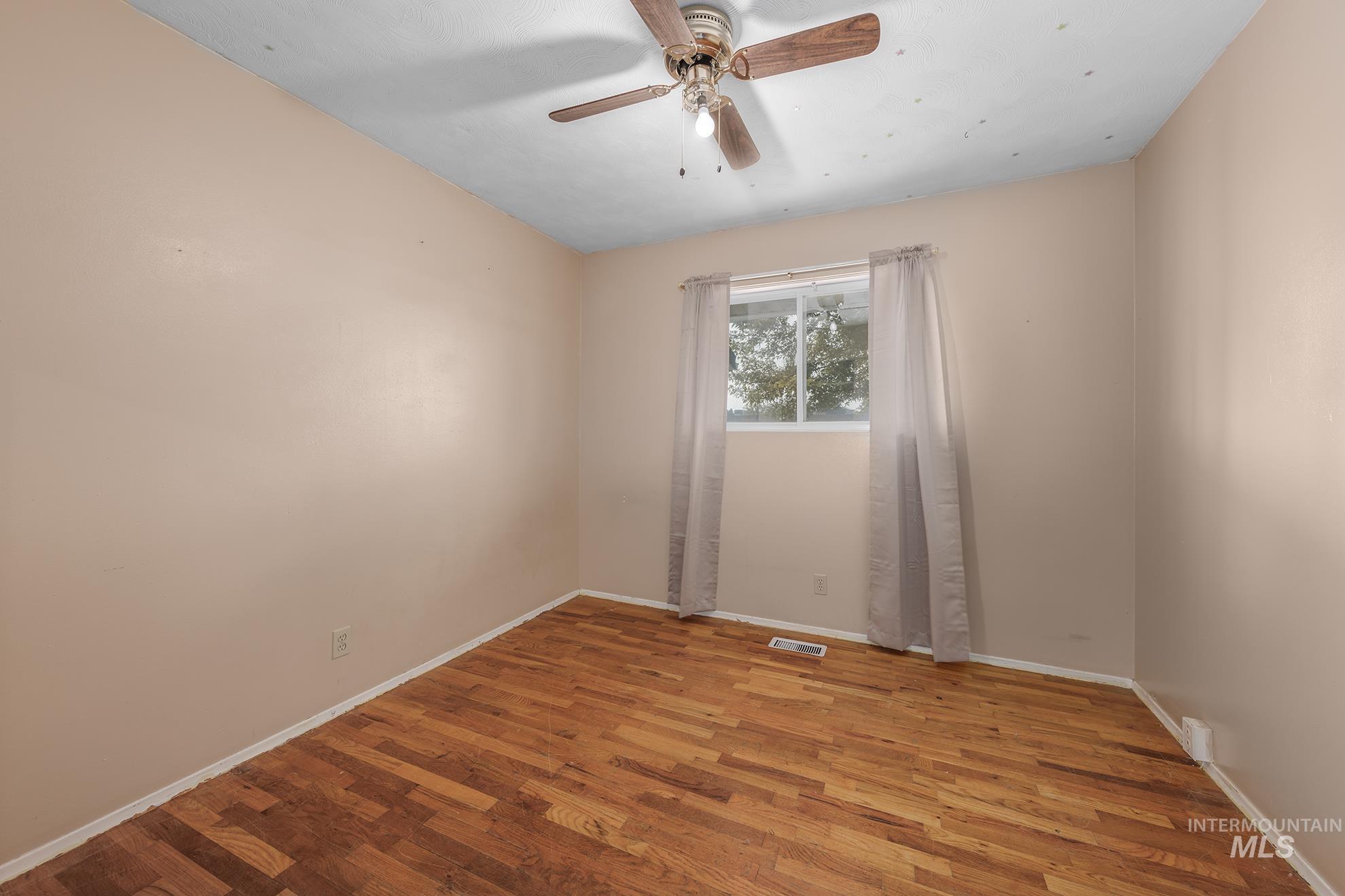 Unfurnished room featuring wood finished floors and ceiling fan