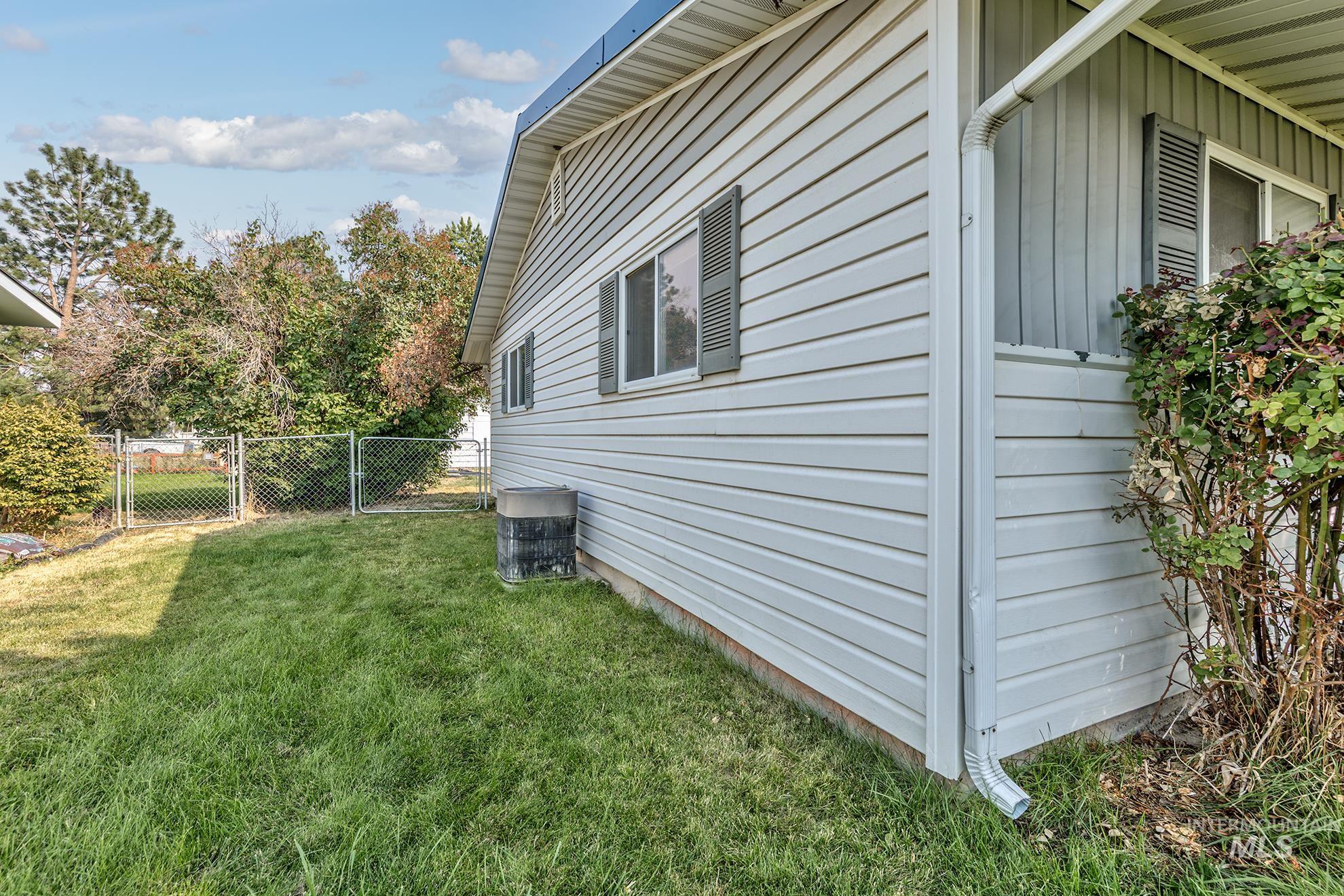 View of side of property featuring board and batten siding and a gate