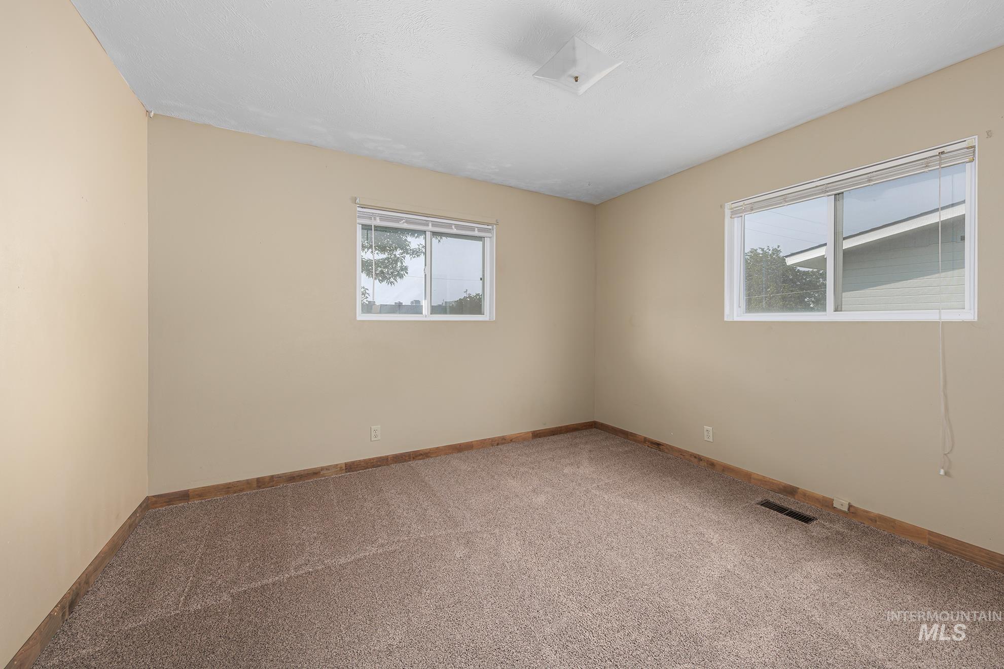 Carpeted spare room with baseboards
