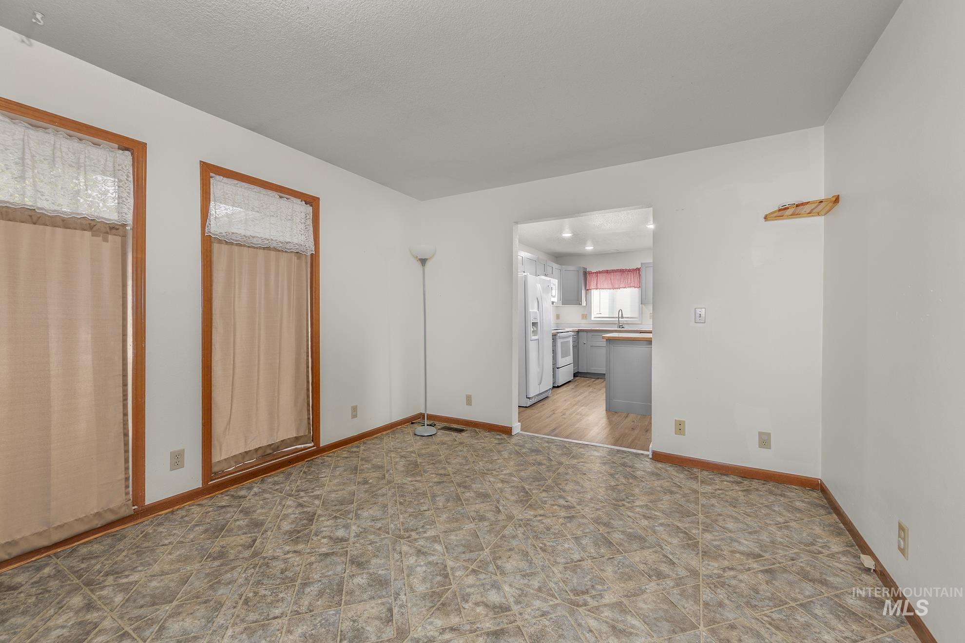 Unfurnished living room featuring baseboards