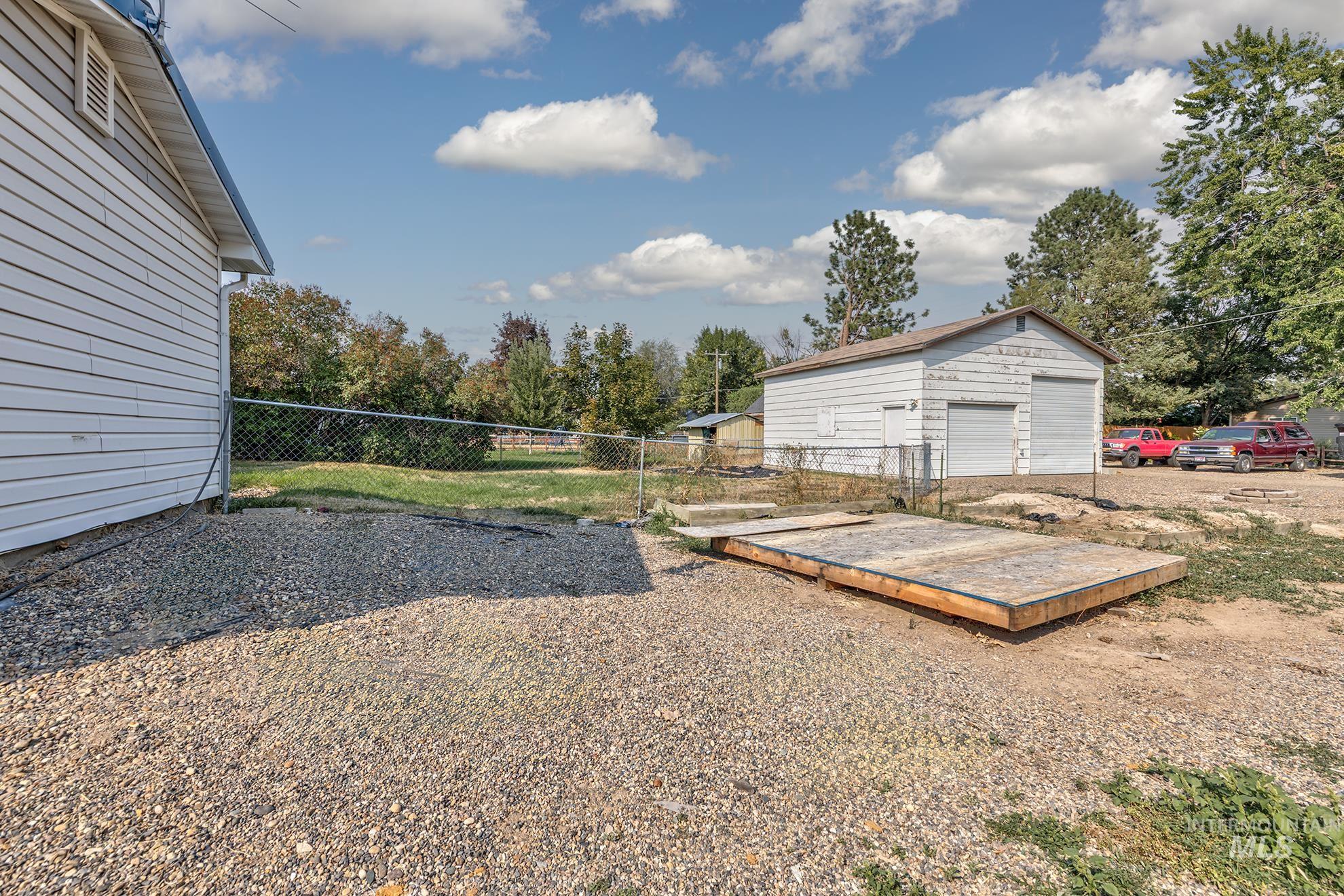 View of yard with a detached garage, an outbuilding, and view of scattered trees