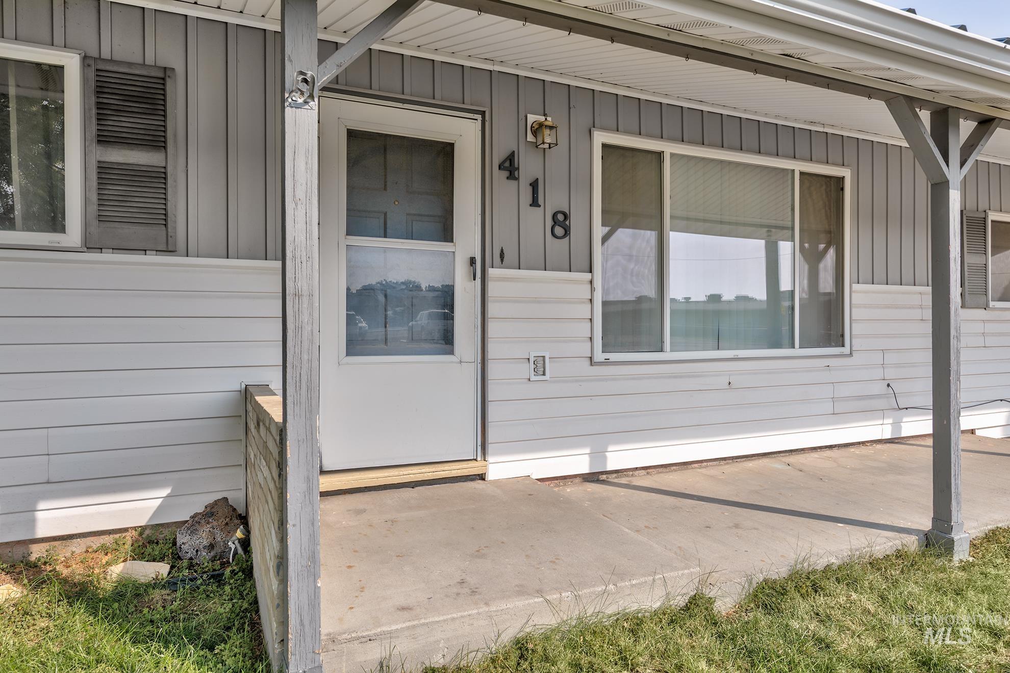 Entrance to property with board and batten siding and a porch