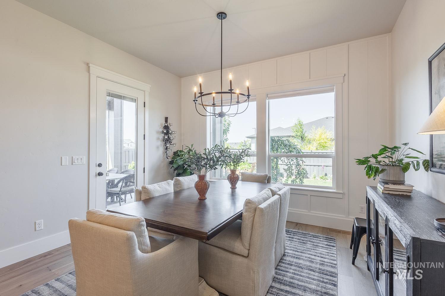 Dining area with a chandelier, plenty of natural light, and light wood finished floors