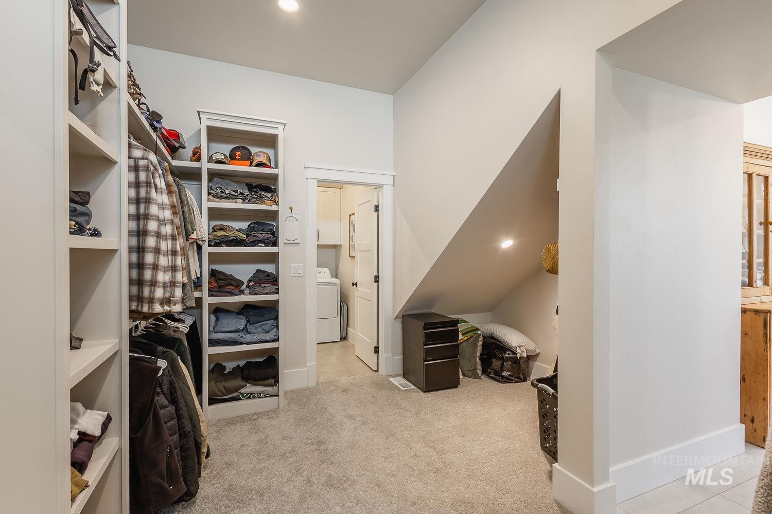 Spacious closet with washer / dryer and carpet