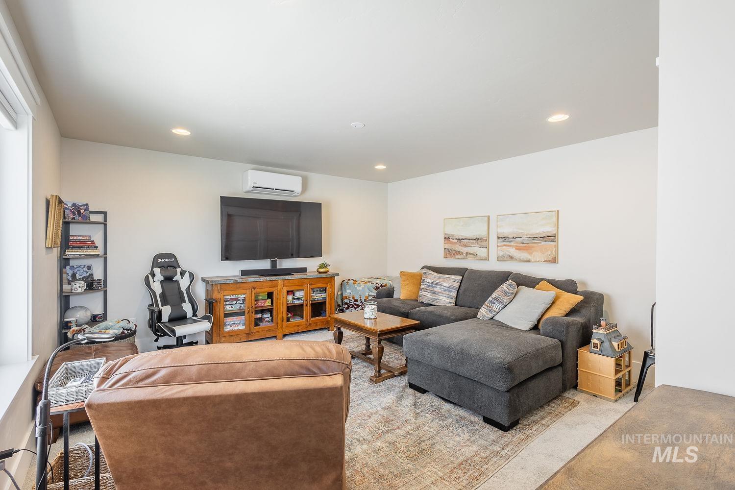 Living room with a wall mounted air conditioner and recessed lighting
