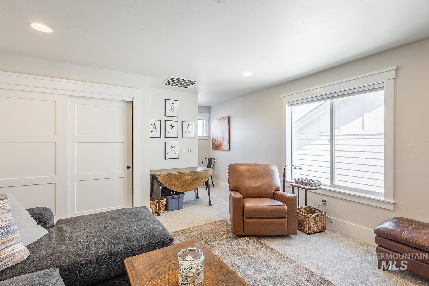 Carpeted living area with recessed lighting