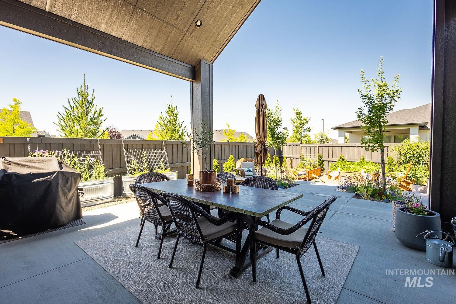 Fenced backyard with a patio, a grill, and outdoor dining area