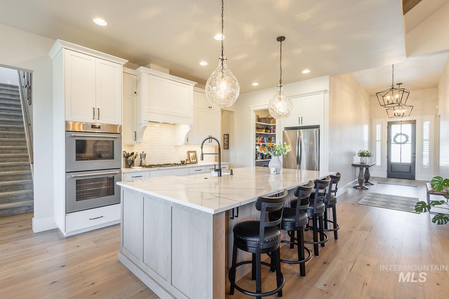 Kitchen with appliances with stainless steel finishes, recessed lighting, backsplash, a large island, and white cabinetry