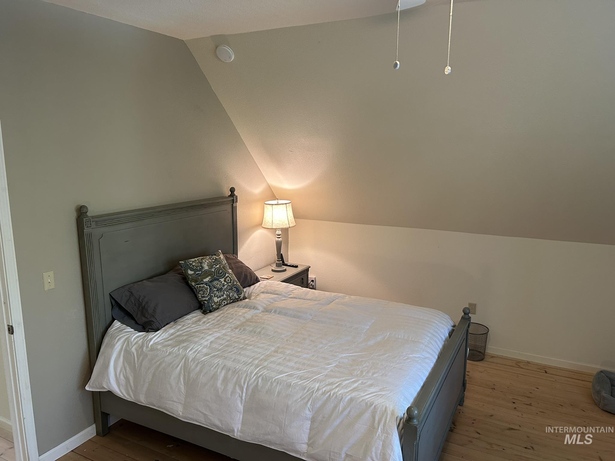 Bedroom with lofted ceiling and light wood-style flooring