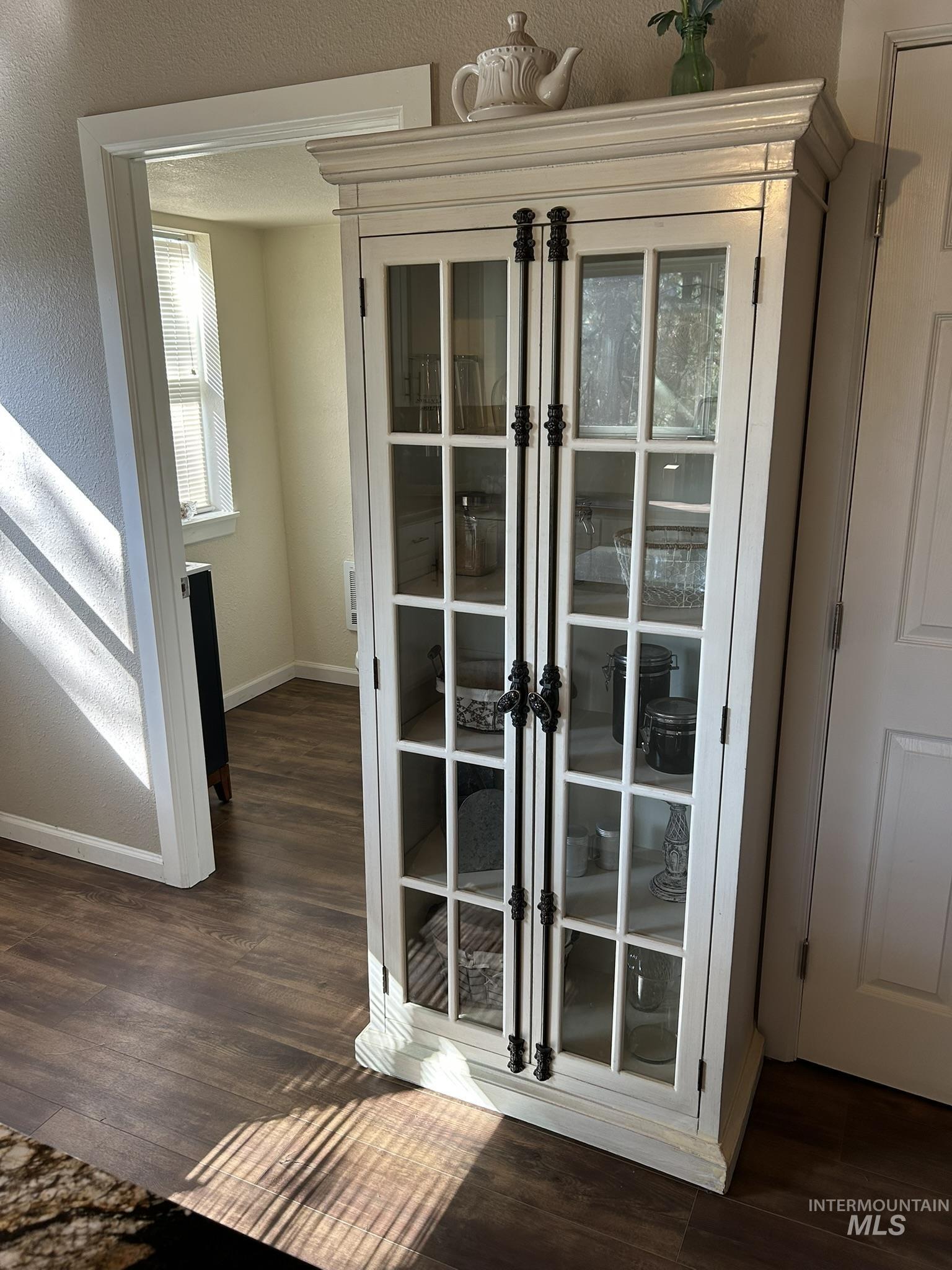Doorway featuring wood finished floors, a textured wall, and french doors
