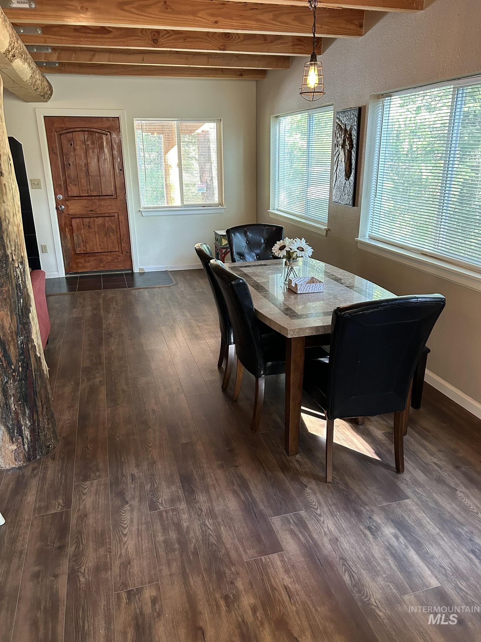 Dining room with dark wood-style floors and beamed ceiling