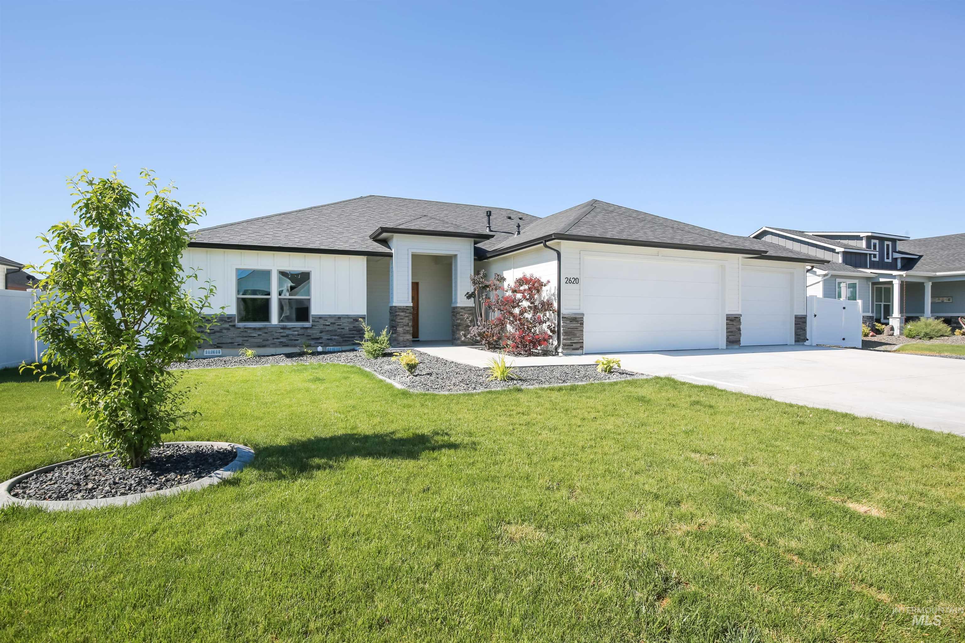 Prairie-style home featuring an attached garage, stone siding, driveway, and roof with shingles