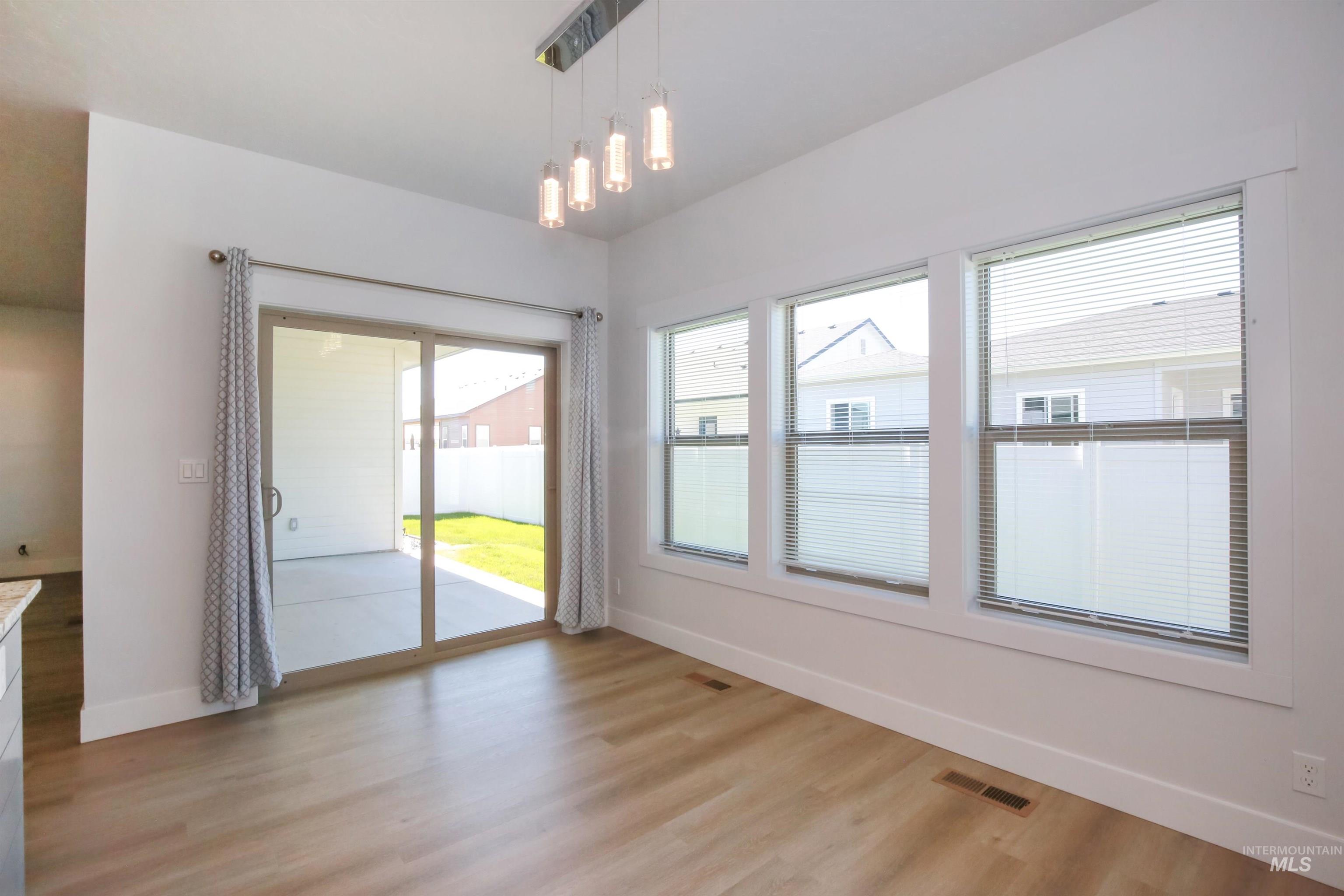 Unfurnished dining area with baseboards and light wood-style floors
