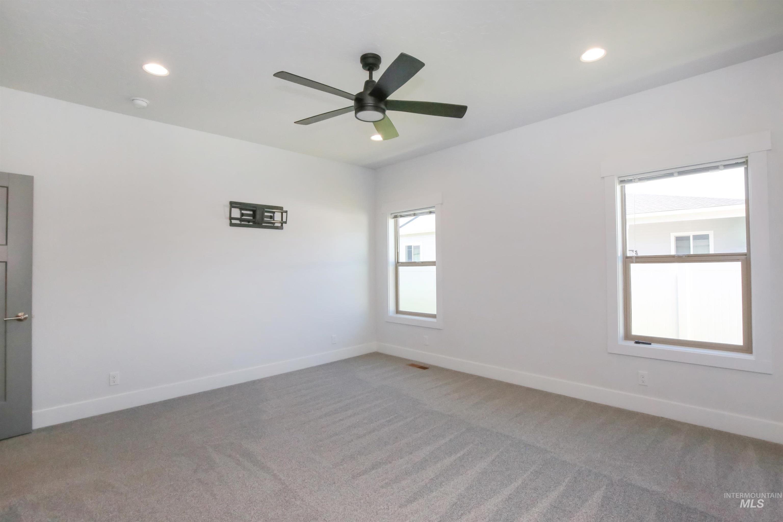 Carpeted empty room featuring recessed lighting and a ceiling fan