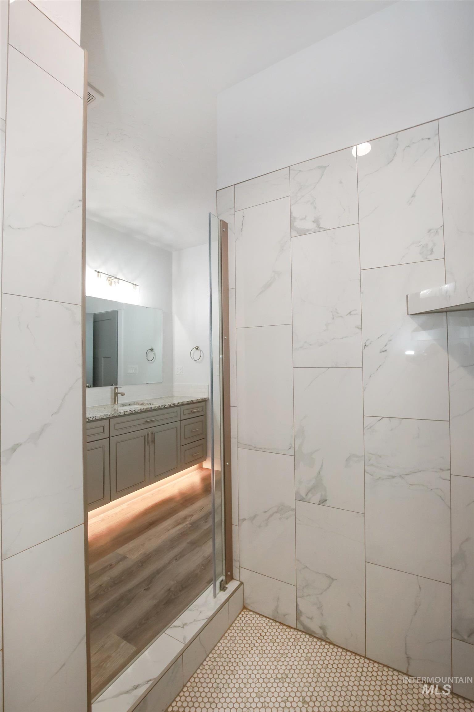 Bathroom featuring vanity and a shower stall