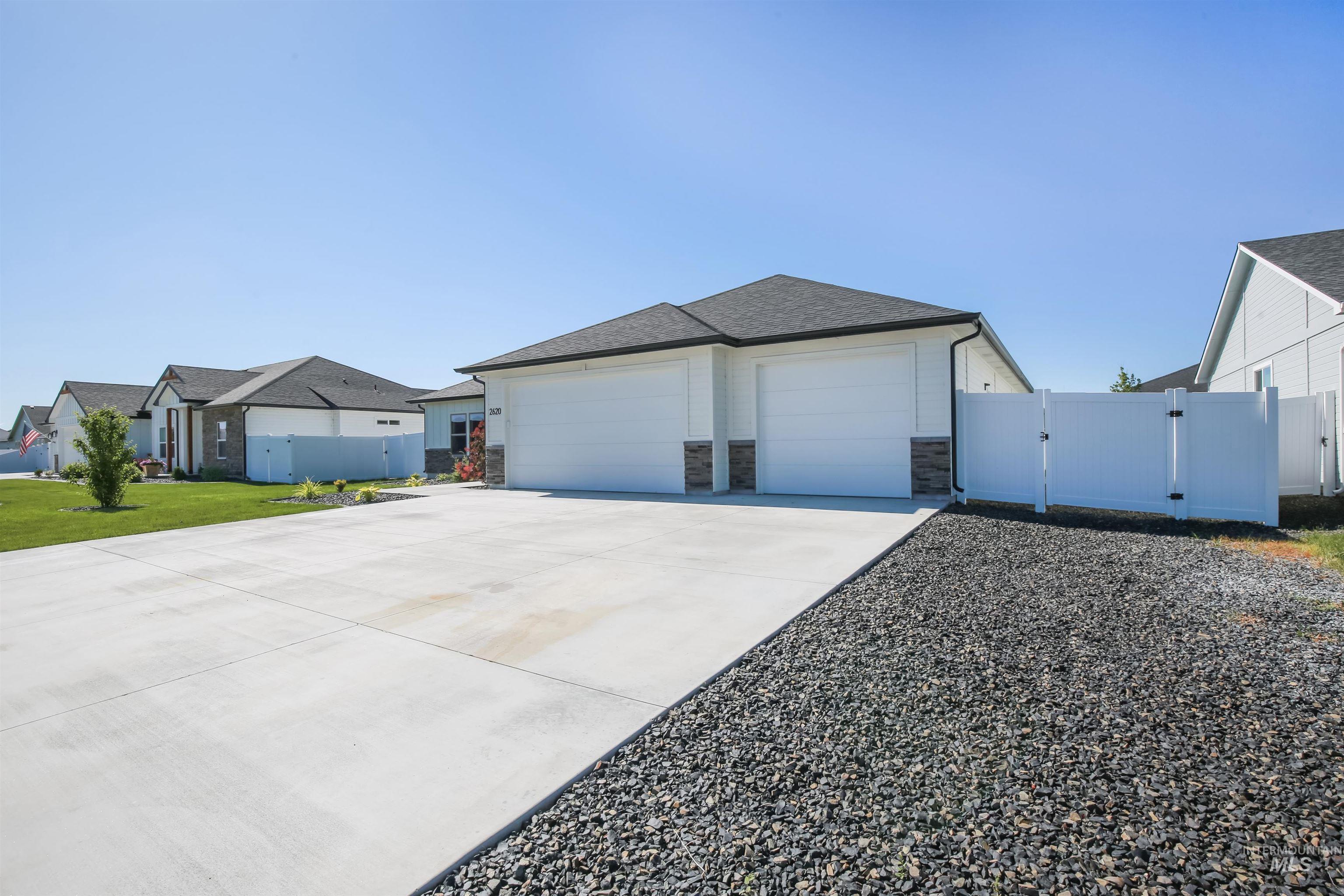 View of property exterior featuring a gate, driveway, stone siding, roof with shingles, and an attached garage