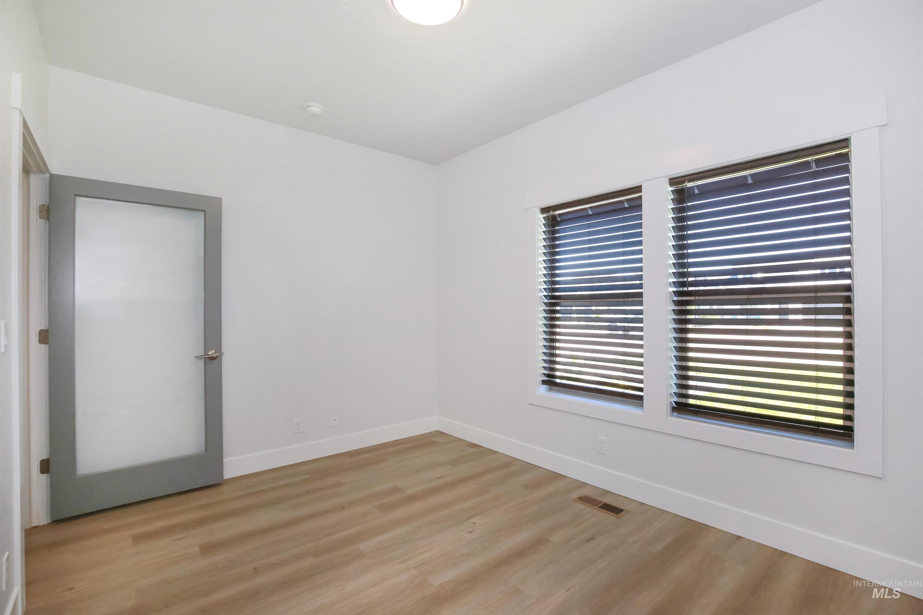 Spare room with baseboards and light wood-style flooring