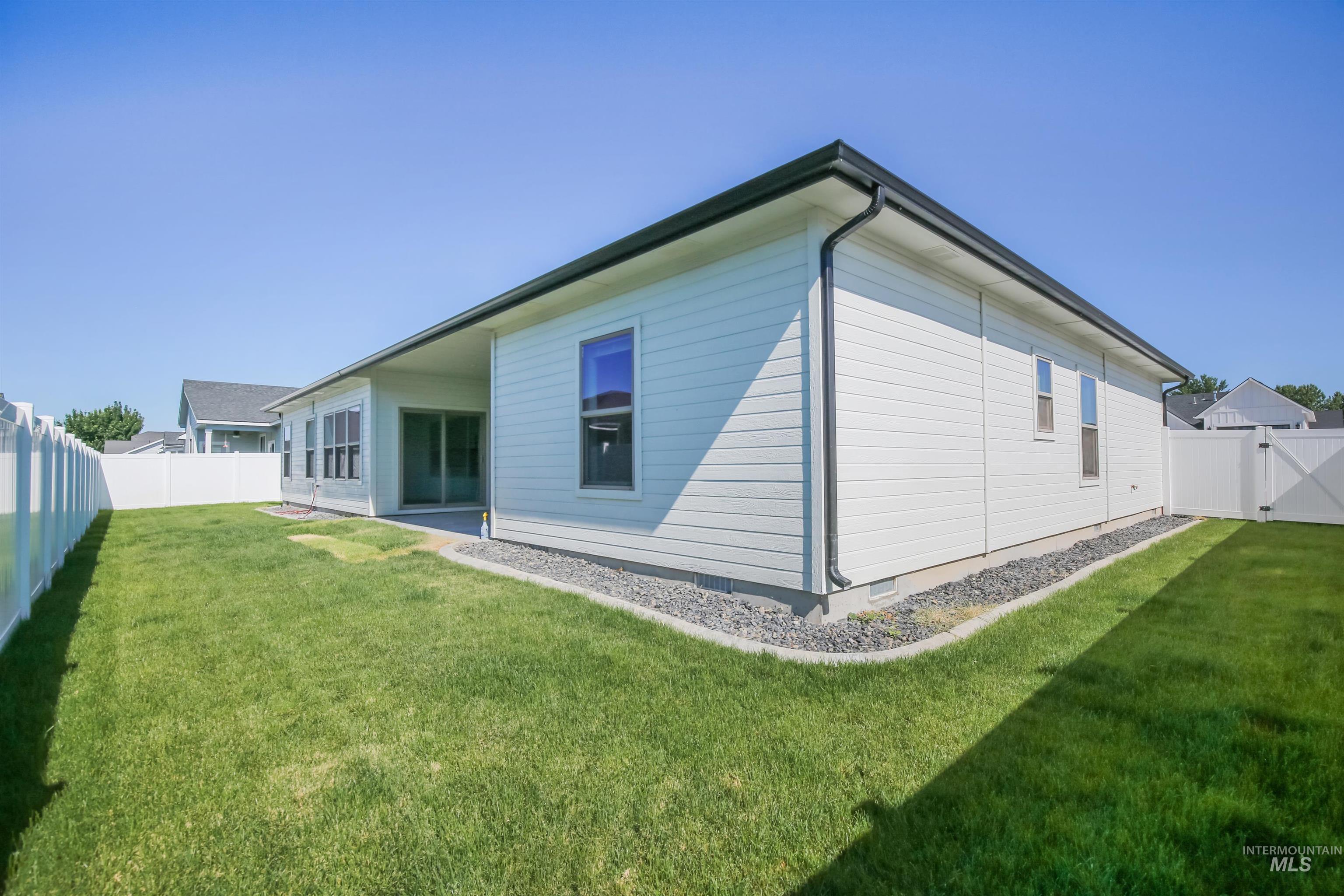 Back of property with a fenced backyard, crawl space, a patio, and a gate