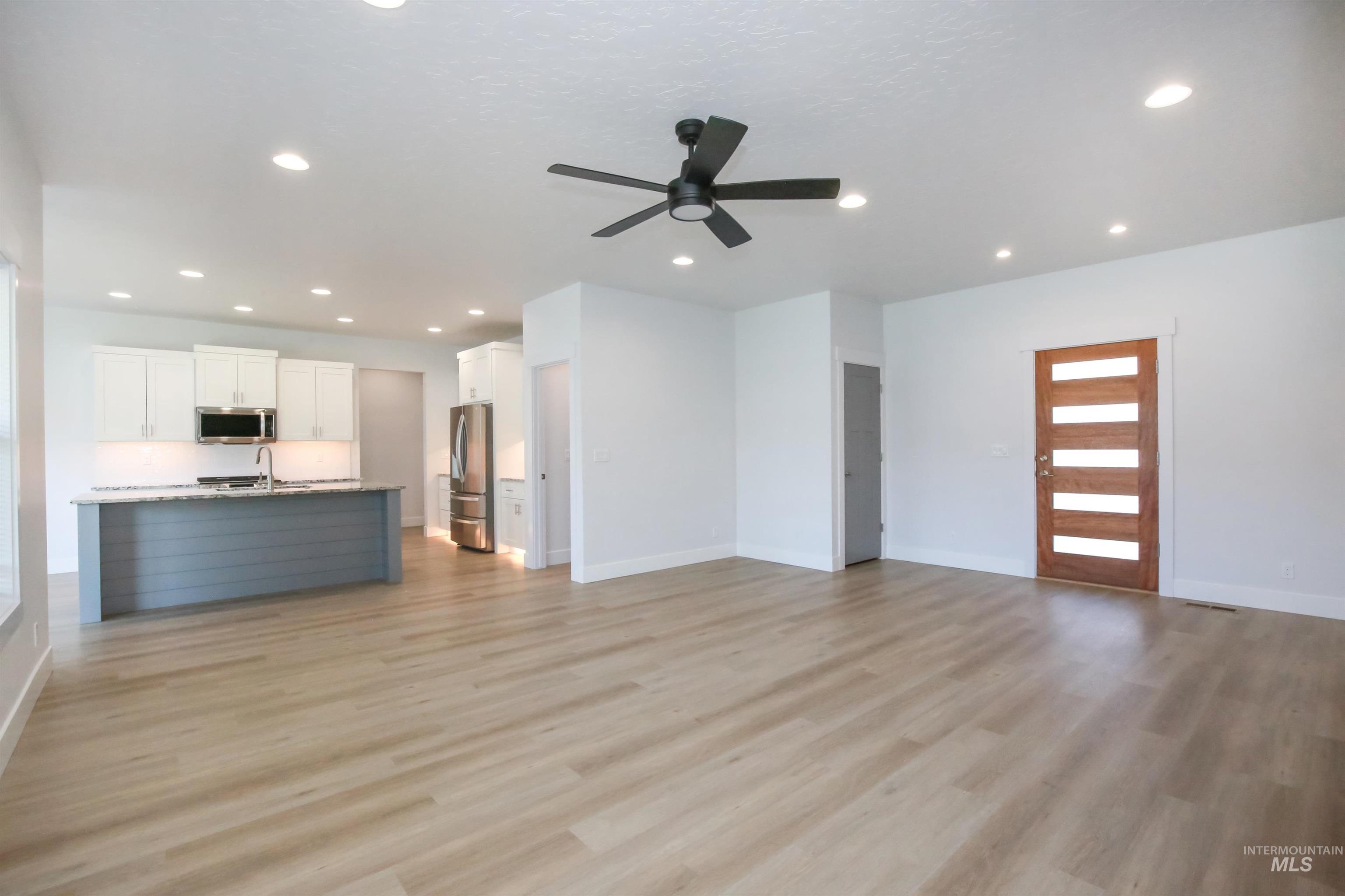 Unfurnished living room featuring light wood finished floors, recessed lighting, and a ceiling fan