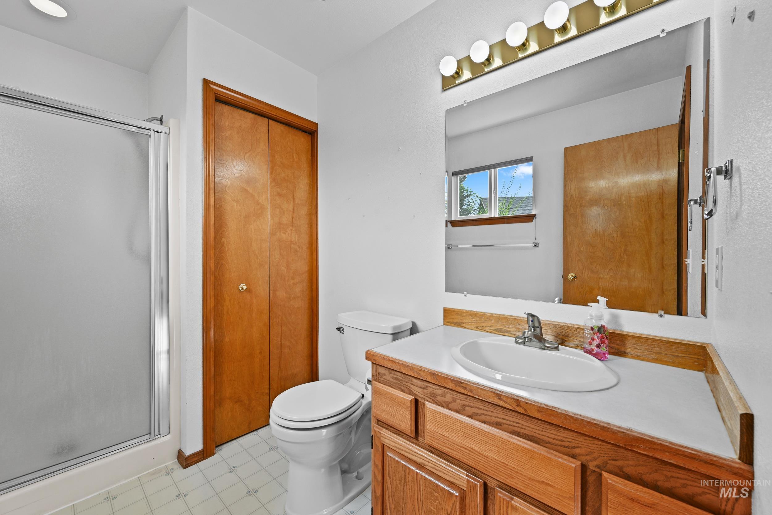 Full bathroom featuring a stall shower and vanity