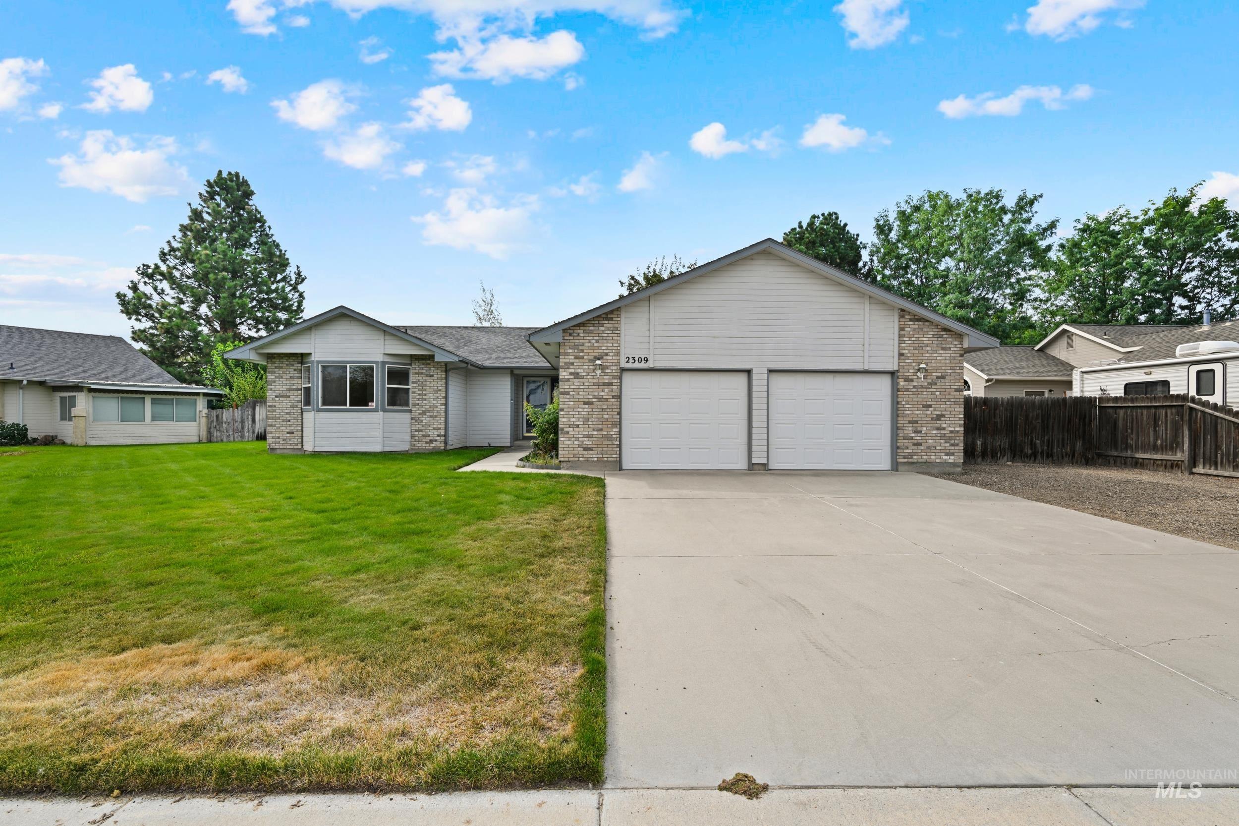 View of front of home with driveway, brick siding, and a garage