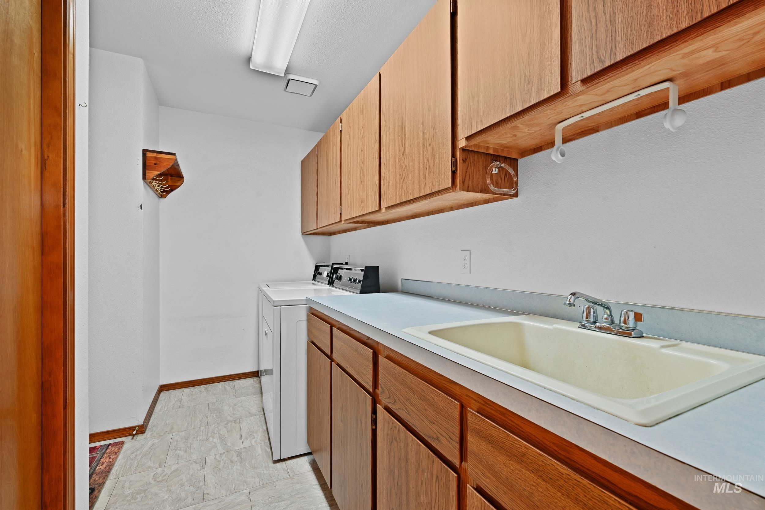 Washroom featuring cabinet space and washing machine and clothes dryer