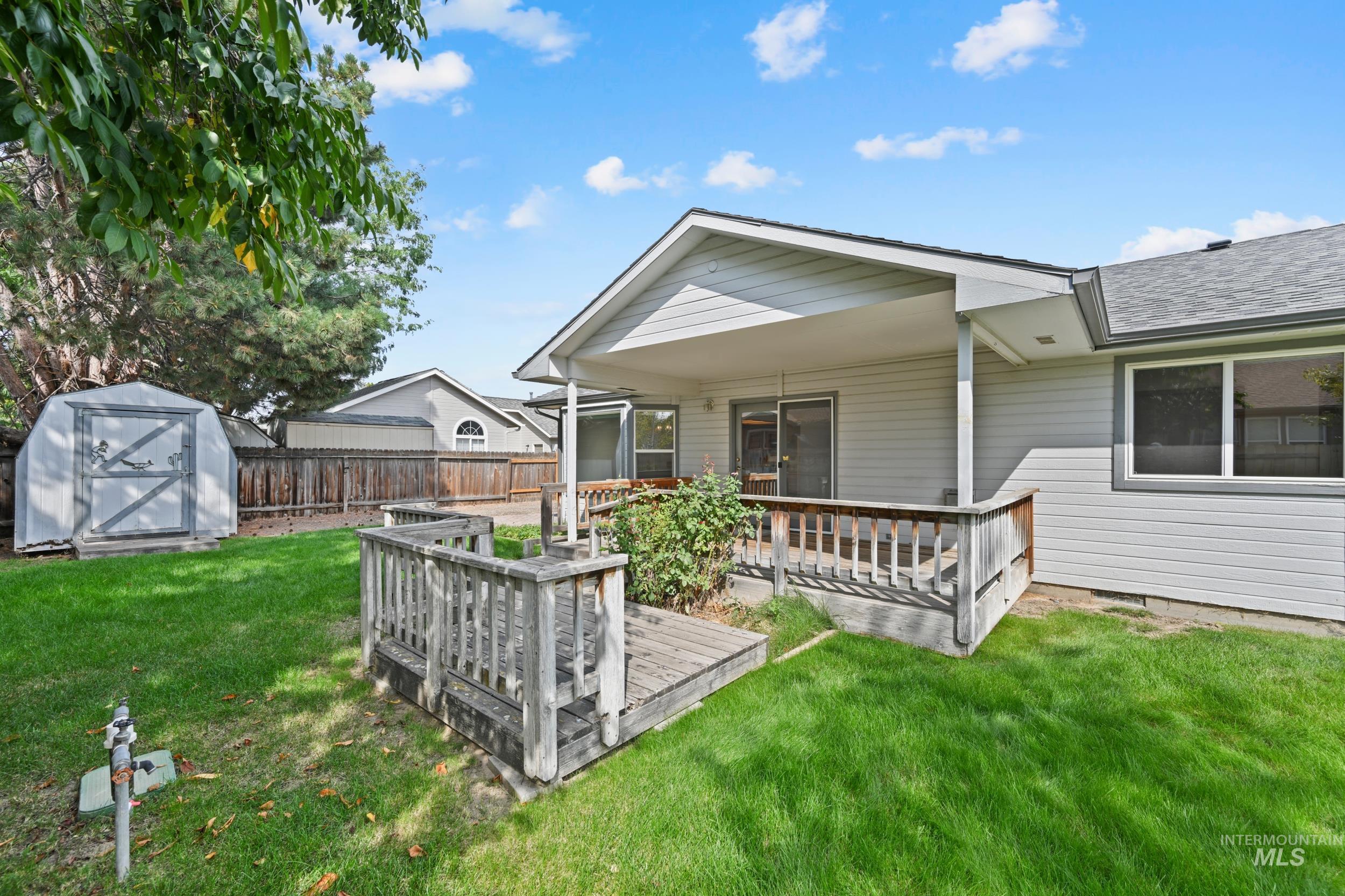 Rear view of house featuring a storage shed and a wooden deck
