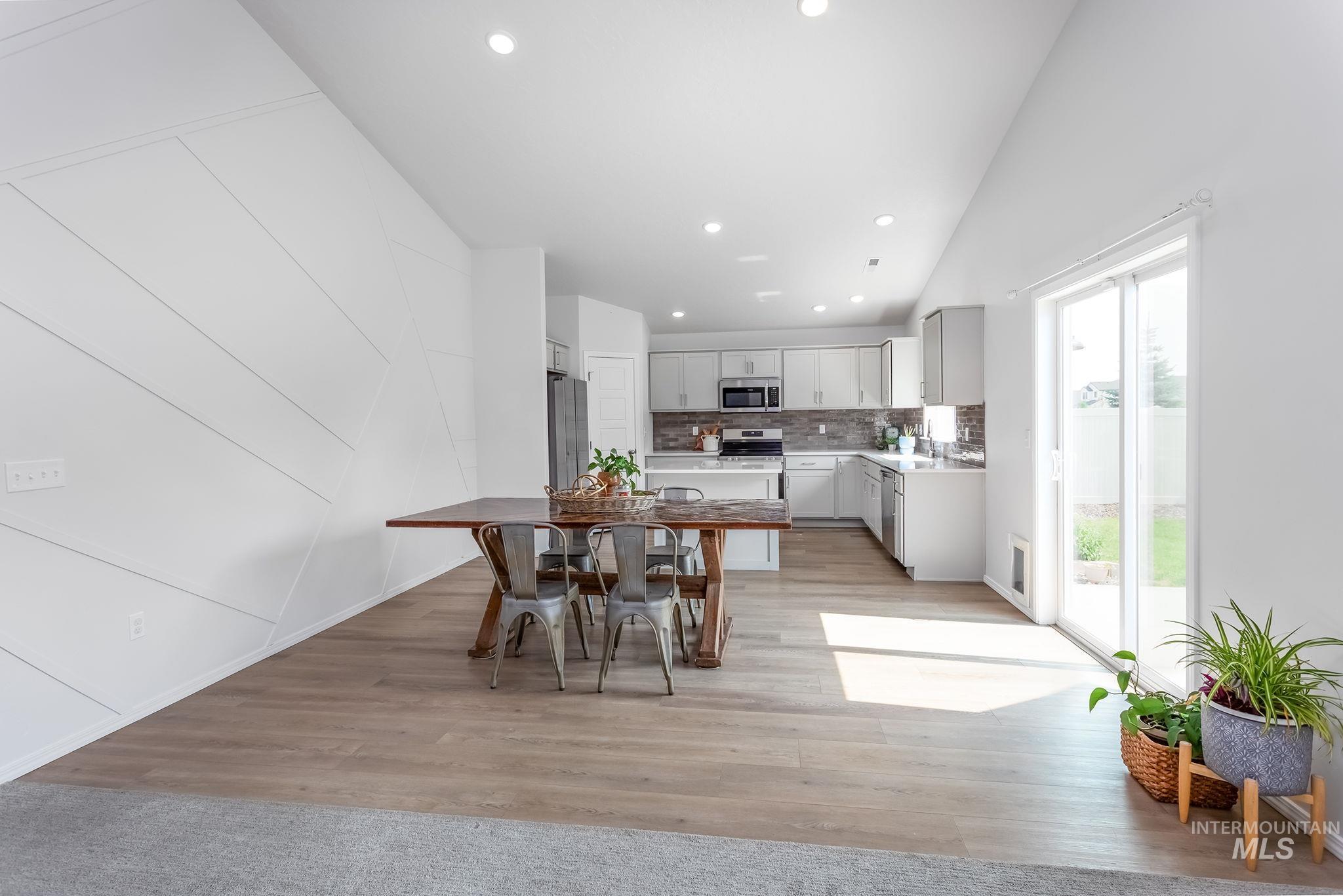 Dining area with recessed lighting, light wood-style flooring, and high vaulted ceiling