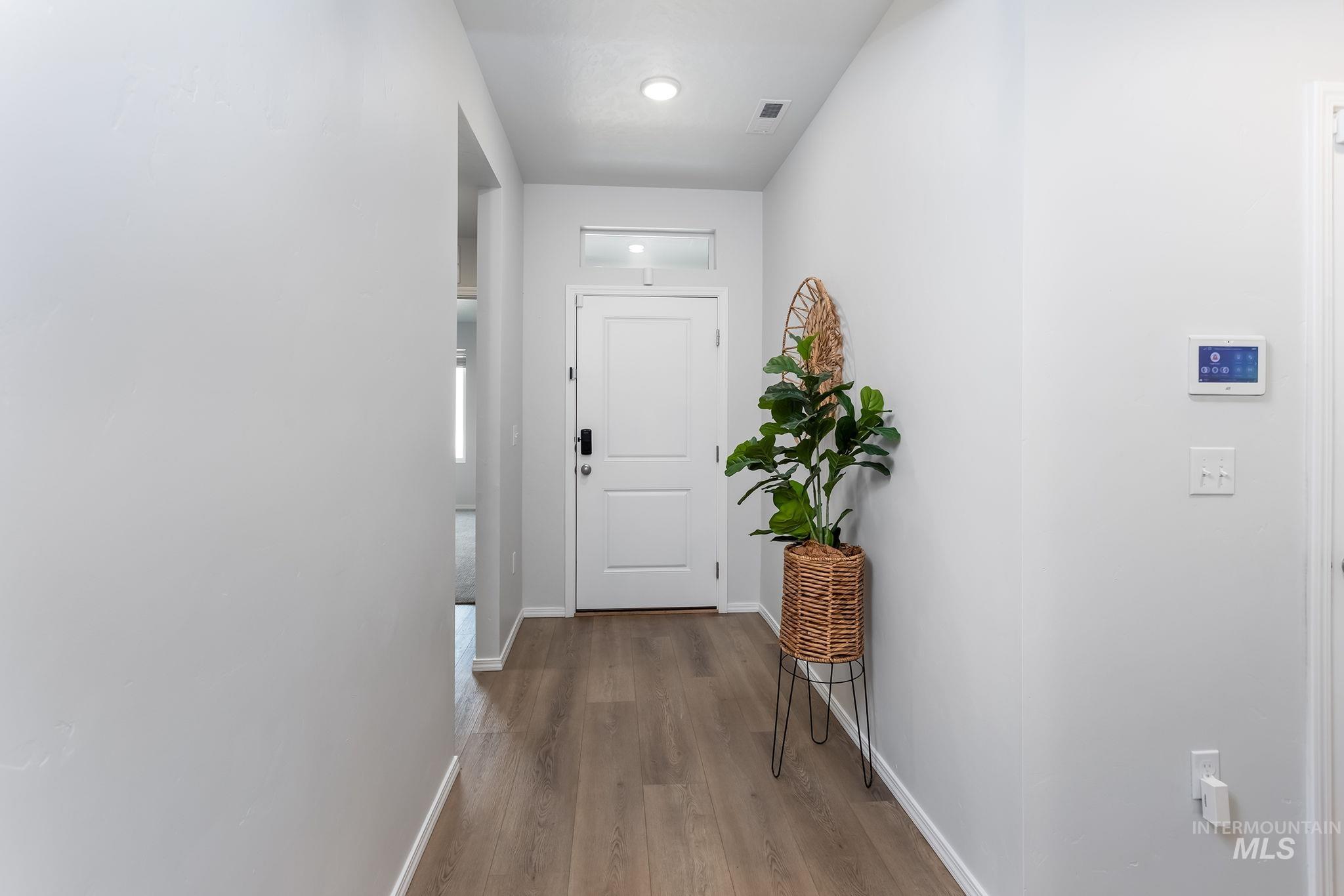 Corridor featuring wood finished floors and recessed lighting