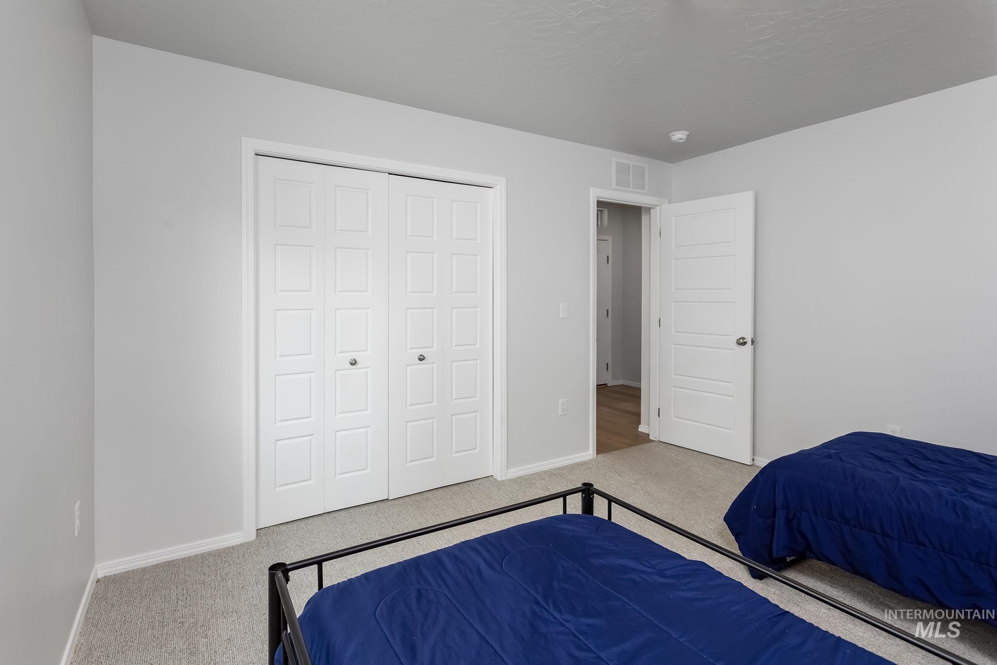 Carpeted bedroom featuring a closet and a textured ceiling