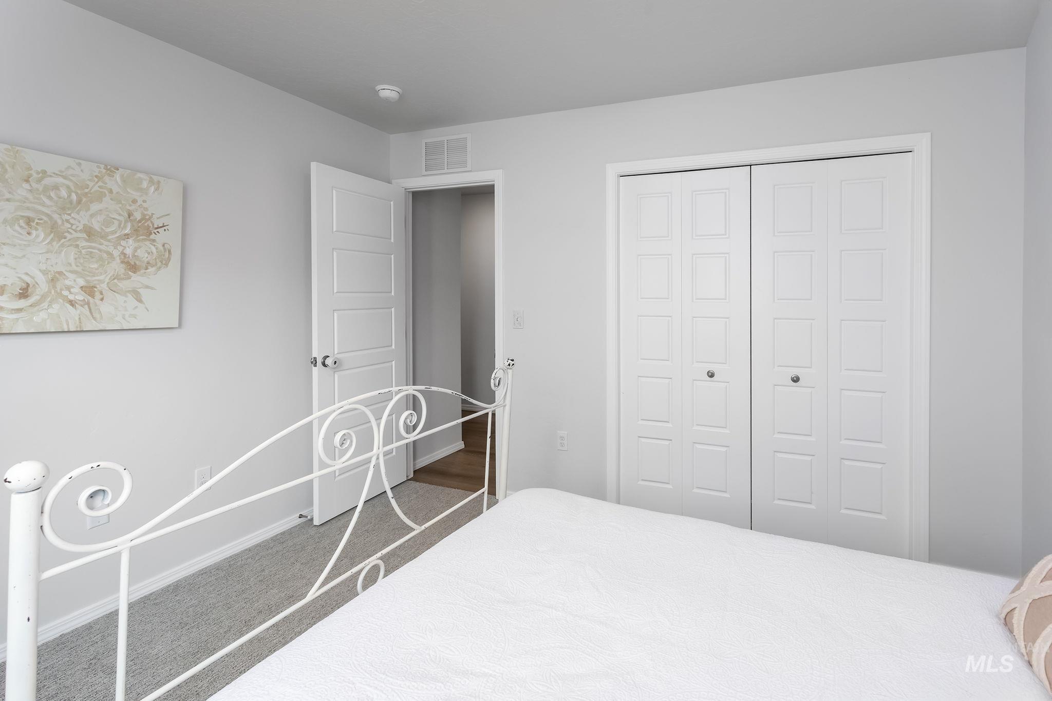 Carpeted bedroom with a closet and baseboards