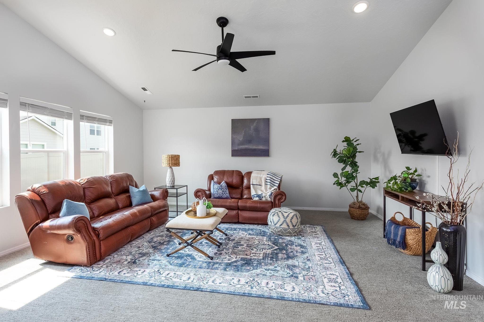 Living area with lofted ceiling, carpet flooring, a ceiling fan, and recessed lighting