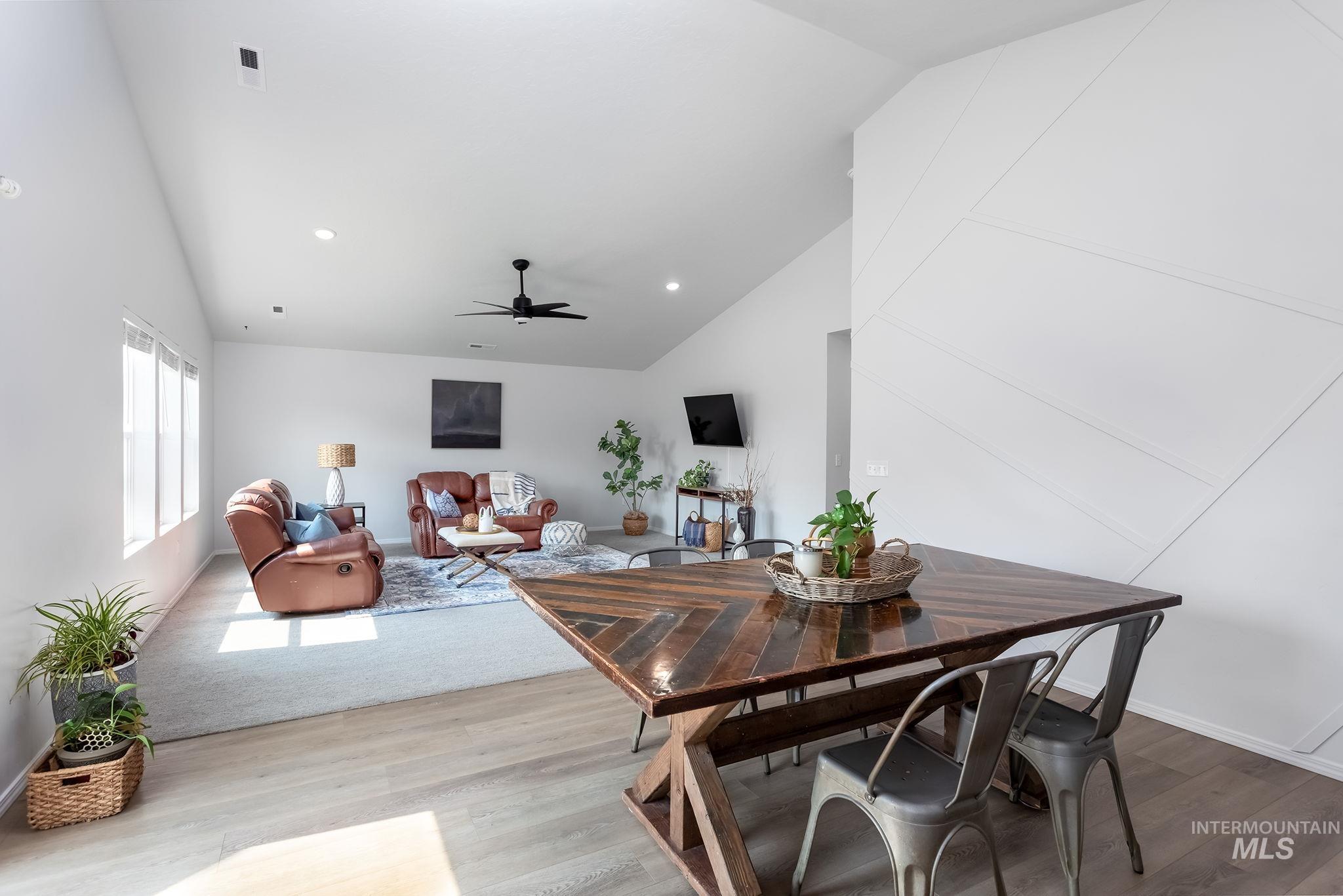 Dining room with vaulted ceiling, recessed lighting, ceiling fan, and wood finished floors