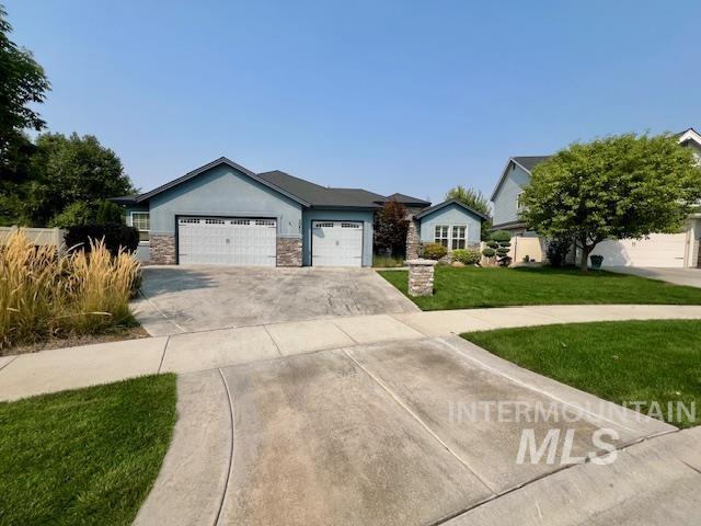 Ranch-style house featuring stone siding, concrete driveway, a garage, a front lawn, and stucco siding