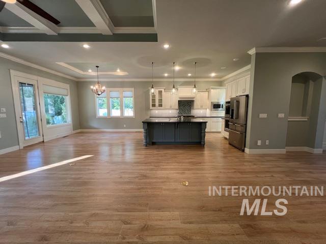 Kitchen with open floor plan, white cabinetry, dark countertops, hanging light fixtures, and recessed lighting