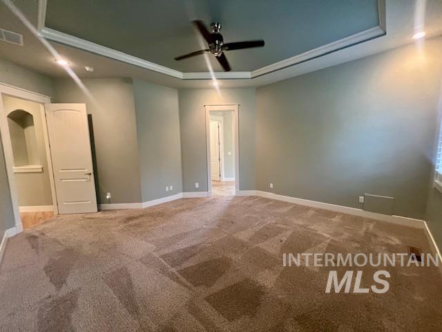 Spare room featuring a tray ceiling, carpet, recessed lighting, and a ceiling fan