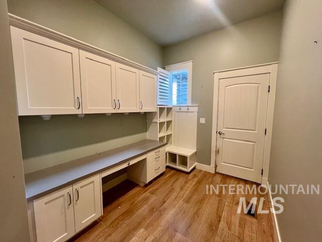 Unfurnished office featuring built in study area and light wood finished floors